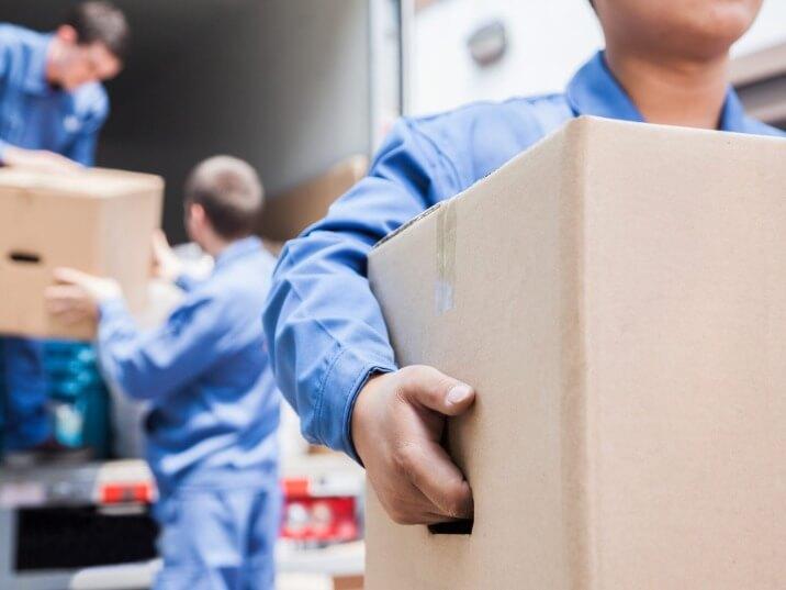 moving crew transporting heavy items down a staircase